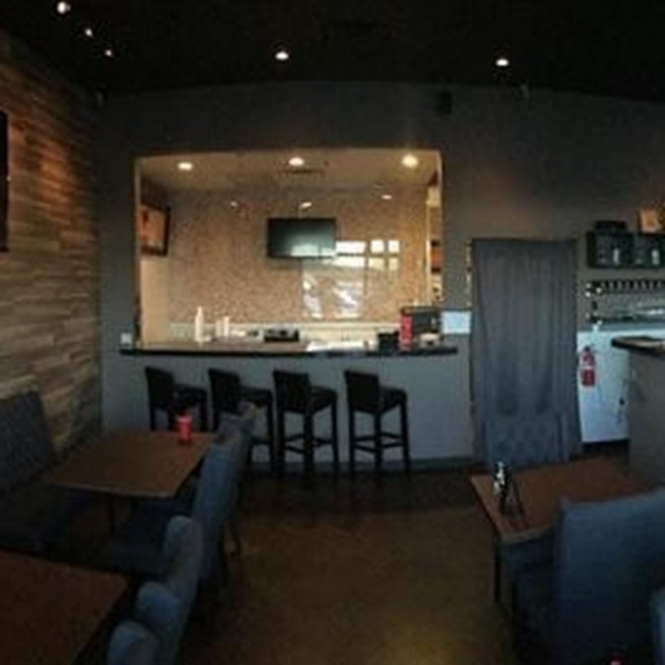 Interior view of Table Thai Bar & Bistro, showing dining tables, chairs, and a bar area.