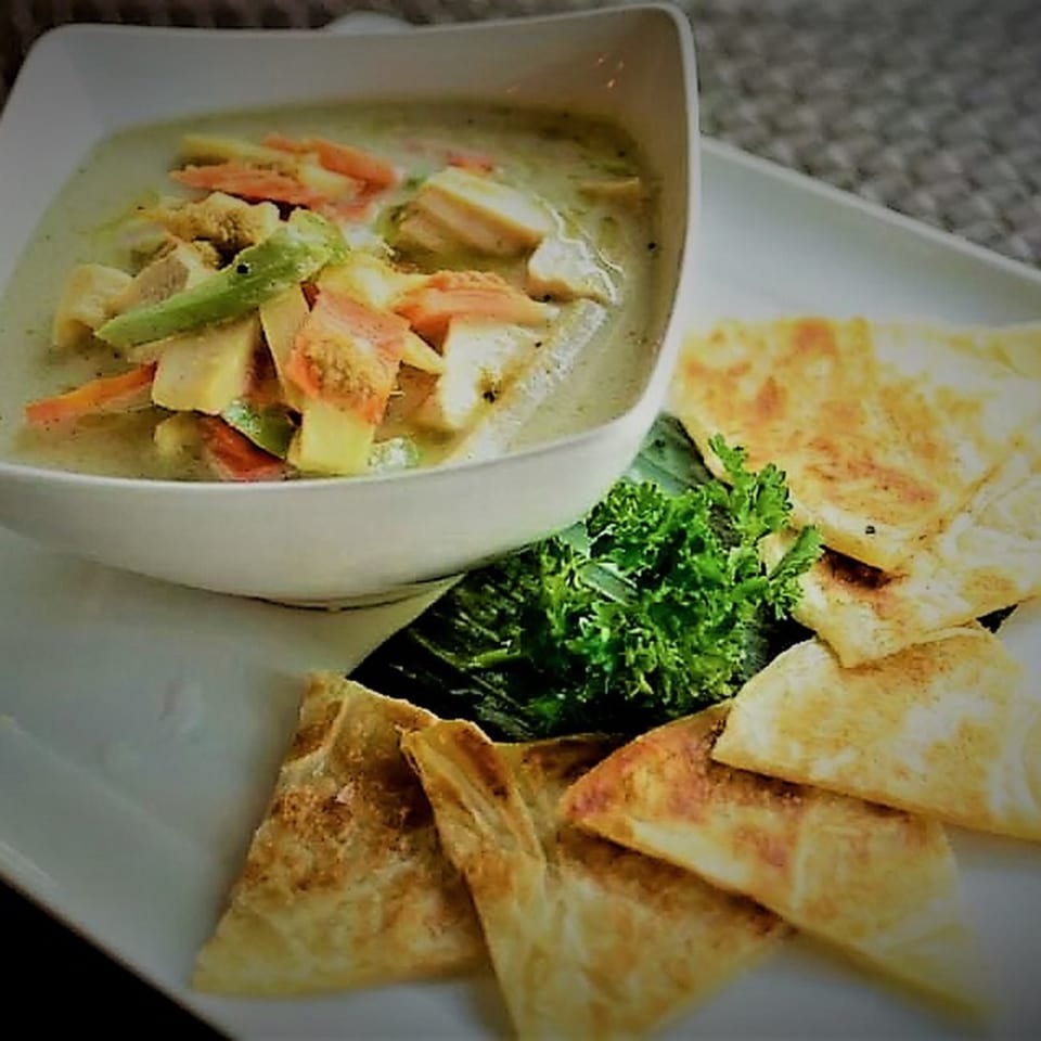 Table Thai Bar & Bistro's green curry with vegetables and chicken, served with crispy roti bread.